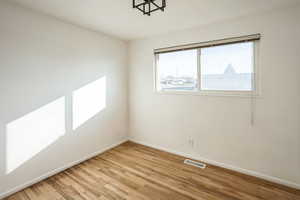 Empty room featuring baseboards and light wood-style flooring