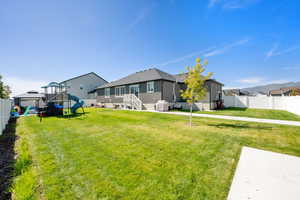Fenced backyard featuring a playground