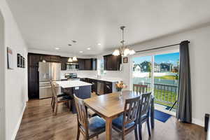 Dining space with dark wood-type flooring, a chandelier, and recessed lighting