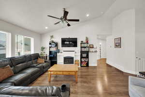 Living area featuring wood finished floors, a ceiling fan, recessed lighting, and high vaulted ceiling