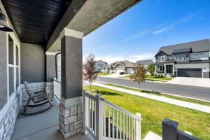 Porch with a residential view and a lawn