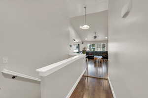Hall featuring an upstairs landing, dark wood-style floors, high vaulted ceiling, and recessed lighting