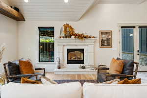 Living room featuring a fireplace, wood finished floors, recessed lighting, and french doors