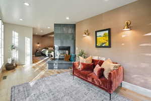 Living area with wood finished floors, recessed lighting, and a tile fireplace