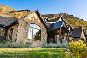 View of side of property with stone siding, covered porch, and a mountain view