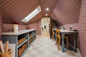 Bonus room with a skylight, vaulted ceiling, wallpapered walls, recessed lighting, and light flooring