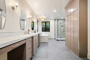 Full bath with double vanity, a bath, a stall shower, light tile patterned floors, and recessed lighting