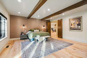 Bedroom featuring beamed ceiling, light wood-style flooring, and recessed lighting