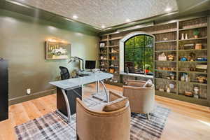 Office space with recessed lighting, wood finished floors, and a textured ceiling