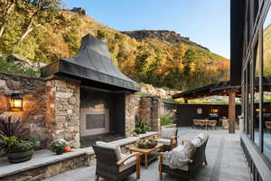 View of patio / terrace featuring an outdoor living space with a fireplace, a gazebo, a mountain view, and outdoor dining space
