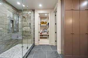Full bath featuring a stall shower, a walk in closet, dark tile patterned floors, and recessed lighting