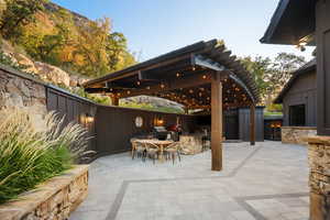 Fenced backyard with an outdoor kitchen, outdoor dining space, a patio area, and a storage unit