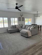 Living room featuring a textured ceiling, a ceiling fan, and wood finished floors
