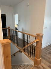 Staircase with wood finished floors and baseboards