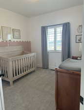 Bedroom featuring light carpet and baseboards