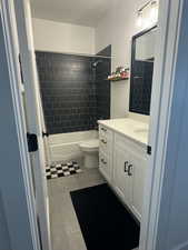 Bathroom featuring vanity, shower / tub combo with curtain, and light tile patterned flooring