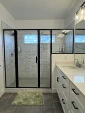Full bathroom with vanity, a marble finish shower, healthy amount of natural light, and a textured ceiling