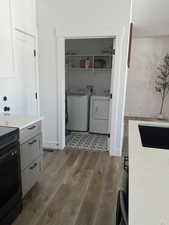 Laundry room featuring independent washer and dryer and dark wood-style flooring