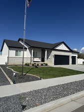 View of front facade with covered porch, brick siding, driveway, and an attached garage