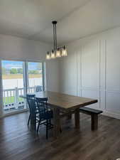 Dining area featuring a textured ceiling, dark wood finished floors, and a decorative wall