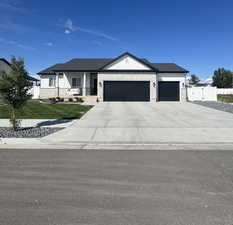 View of front facade with a porch, concrete driveway, a garage, and brick siding