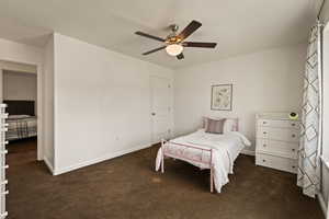 Bedroom featuring dark carpet and a ceiling fan