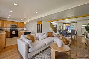 Living room with stairs, recessed lighting, and light wood-type flooring