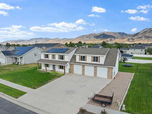 Traditional home featuring a residential view, driveway, covered porch, and a mountain view
