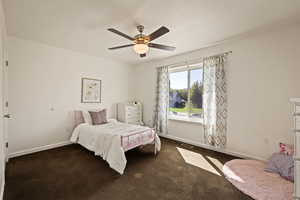 Bedroom featuring dark colored carpet and ceiling fan