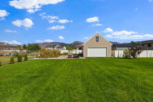 Fenced backyard featuring a mountain view, a garage, and a patio area