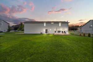 Back of house at dusk featuring a wooden deck