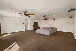 Unfurnished living room featuring dark colored carpet, recessed lighting, and a ceiling fan