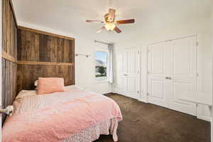 Bedroom featuring carpet, two closets, and a ceiling fan