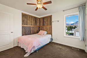 Bedroom featuring carpet floors, ceiling fan, and a mountain view