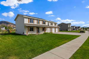 View of front of property with driveway, a mountain view, a porch, and a garage