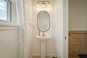 Full bath with baseboards and a shower with shower curtain