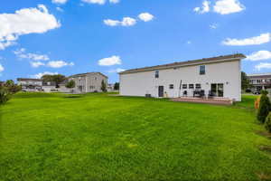 Back of property featuring a deck and a yard
