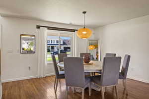 Dining room with hardwood / wood-style flooring and a textured ceiling