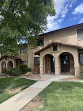Mediterranean / spanish-style house with a front yard, stucco siding, and brick siding