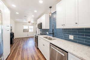 Kitchen with white cabinets, recessed lighting, and a textured ceiling