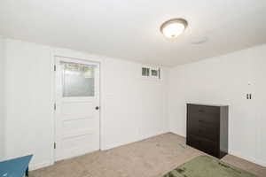 Bedroom with carpet floors, multiple windows, and wood walls