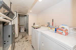 Laundry room featuring heating unit, independent washer and dryer, recessed lighting, and a textured ceiling