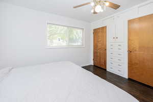 Bedroom featuring dark wood-type flooring, a ceiling fan, and a closet