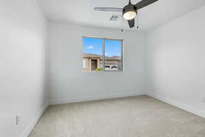 Empty room with light carpet and a ceiling fan