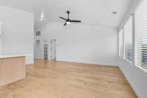 Unfurnished room featuring light wood-style floors, high vaulted ceiling, and a ceiling fan