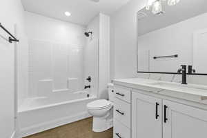 Full bathroom featuring  shower combination, vanity, recessed lighting, and dark wood-type flooring