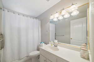 Bathroom featuring vanity, shower / bathtub combination with curtain, and light tile patterned floors