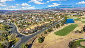 Aerial overview of property's location featuring nearby suburban area, a water and mountain view, and a golf course