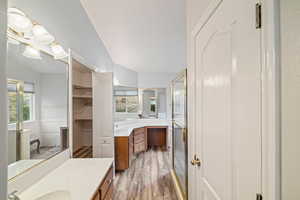 Full bathroom with vanity, a stall shower, and light wood-type flooring