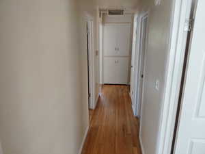 Hallway featuring light wood-style flooring and baseboards